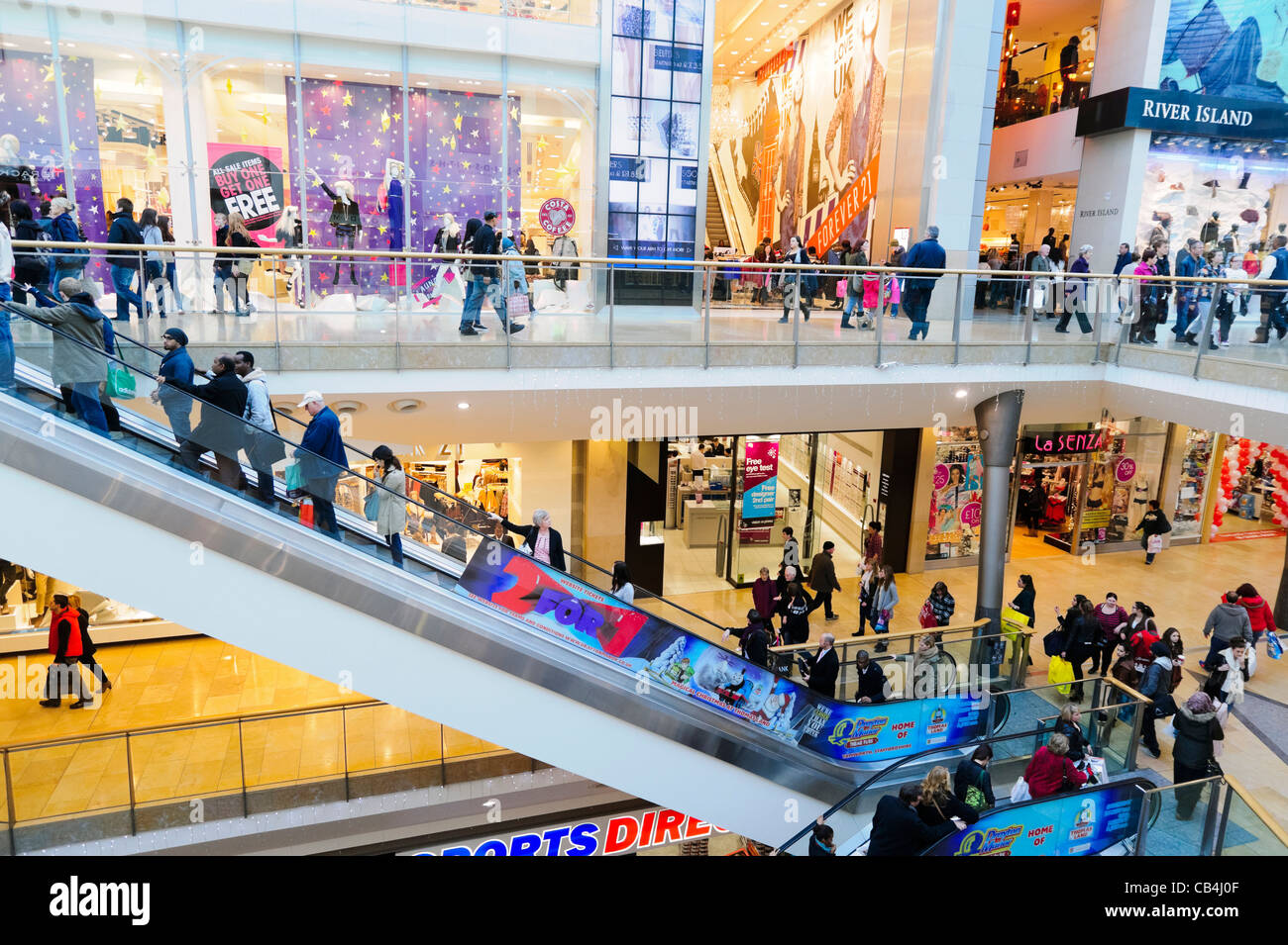Bullring Shopping Centre interno, Birmingham, Regno Unito. Le persone che usano un escalator a Bullring Shopping Mall. Foto Stock