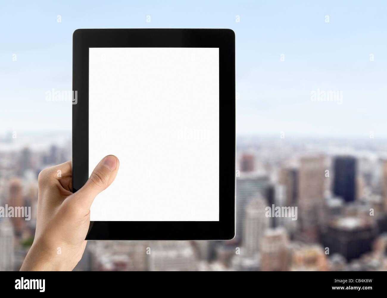 L'uomo le mani sono tenendo un dispositivo touchscreen con schermo vuoto. Paesaggio urbano sfocate con grattacieli sullo sfondo. Foto Stock