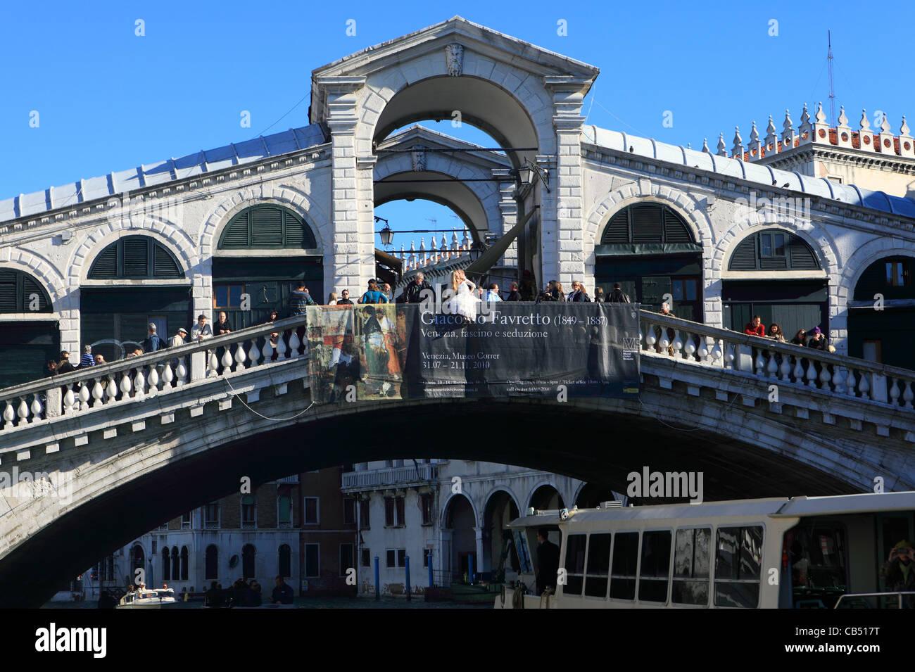 Una sposa posatoi sul parapetto del Ponte di Rialto a Venezia (Italia), per una foto con il suo sposo. Foto Stock