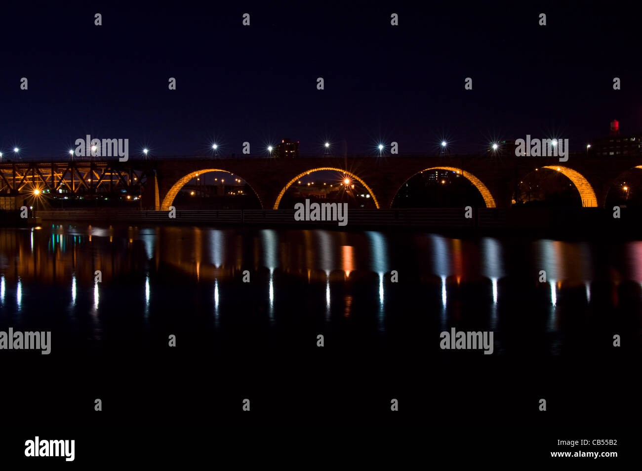 Arco in pietra Bridge e bloccare e diga spanning Fiume Missisippi in Minneapolis Minnesota di notte Foto Stock