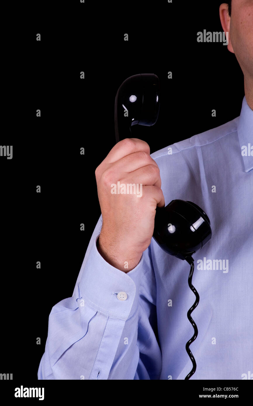 Imprenditore con il ricevitore del telefono in mano (isolato su nero) Foto Stock