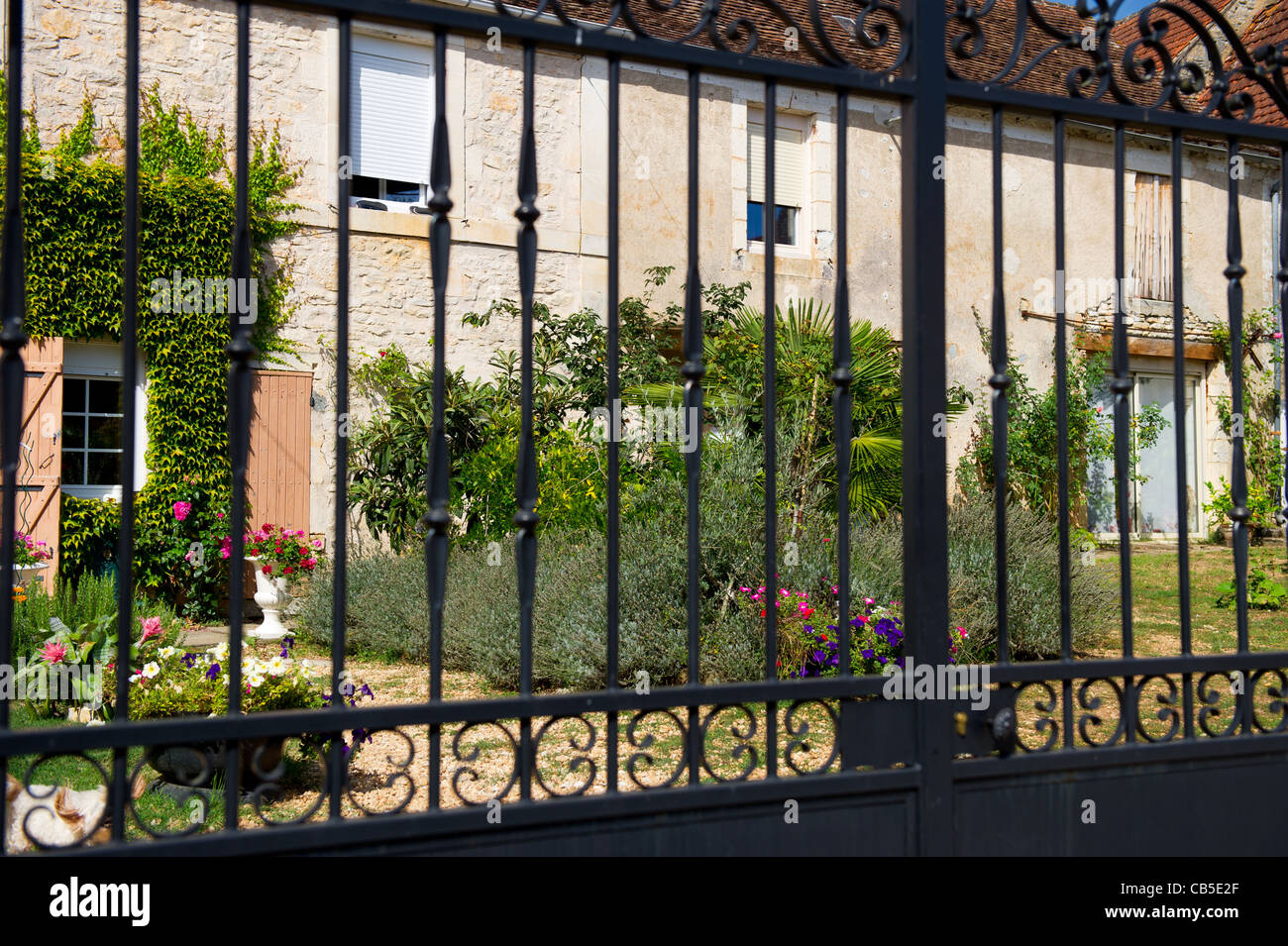 Giardino con fiori dietro la recinzione in Francia Foto Stock