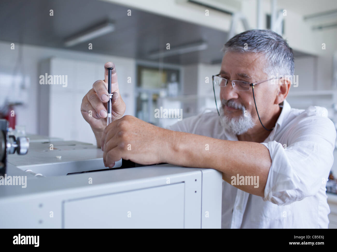 Maschio senior researcher di effettuare attività di ricerca scientifica in un laboratorio usando un cromatografo a gas Foto Stock