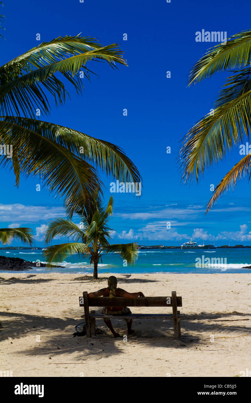 L'uomo rilassante sotto le palme sulla spiaggia nelle isole Galapagos Foto Stock