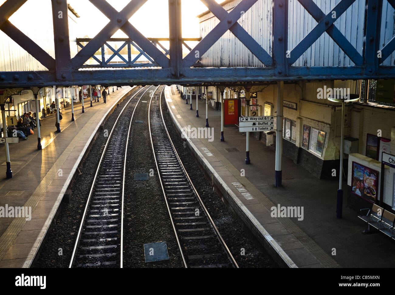 Fine della giornata - luce solare bassa evidenziando i binari di una stazione ferroviaria. Regno Unito. Foto Stock