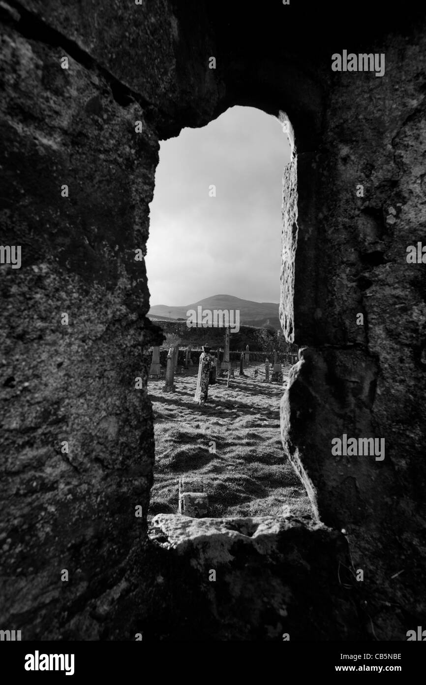 Guardando attraverso una finestra della vecchia cappella nel cimitero Pennygowan (Caol Fhaoileann), Salen Isle of Mull, Scozia. Foto Stock