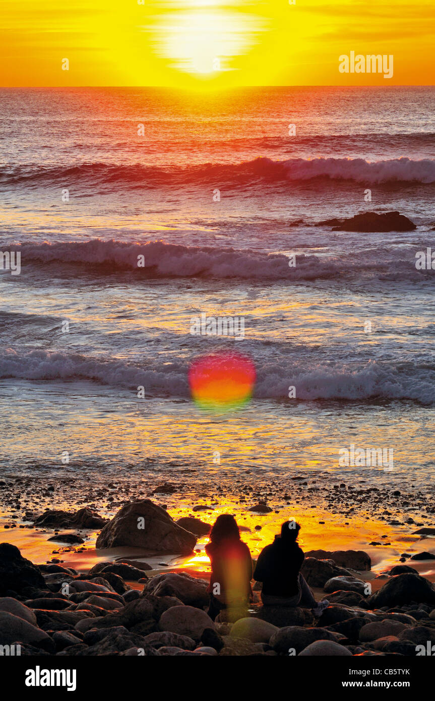 Il Portogallo, Algarve: giovane guardando il tramonto alla spiaggia Praia do Tonel in Sagres Foto Stock