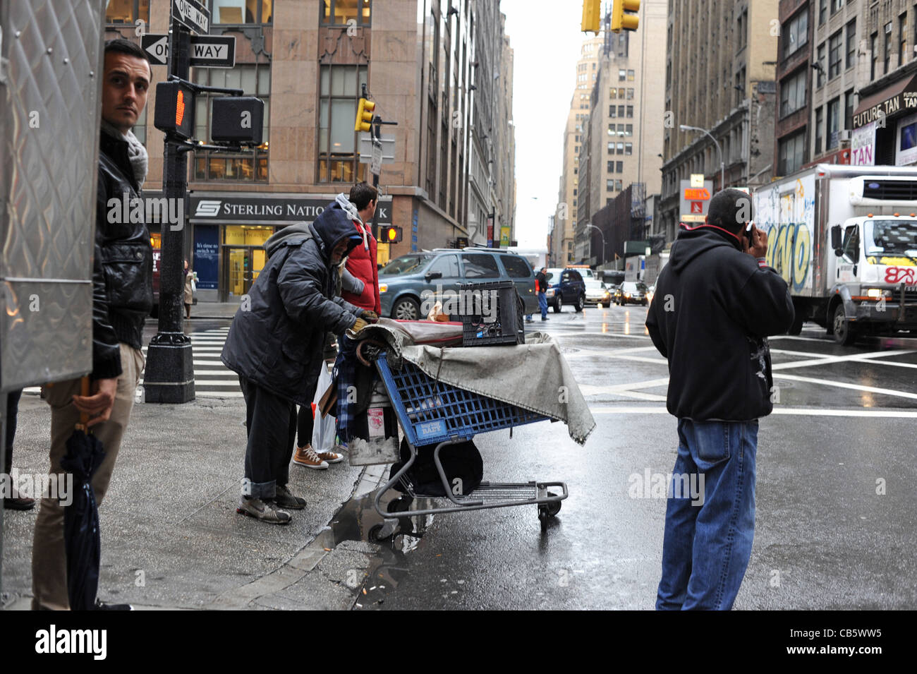 Senzatetto maschio con carrello della spesa pieno di cose a piedi nel traffico Manhattan New York New York STATI UNITI D'AMERICA Foto Stock