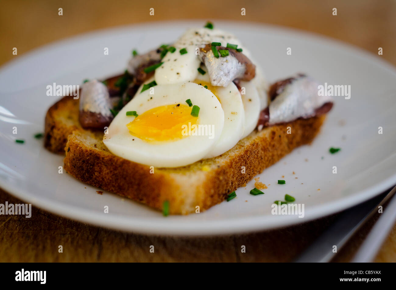 Un classico svedese aperto di fronte sandwich con affettati, uova sode, guarnita con conserve ansjovis svedese (decapati spratti) Foto Stock