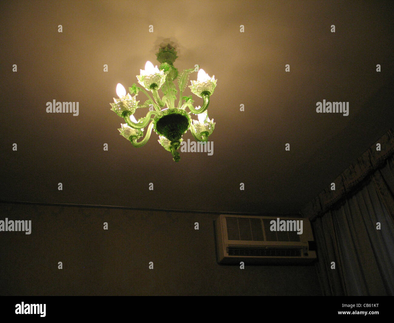 Verde lampadario di vetro in una cupa stanza in hotel, Venezia, Italia Foto Stock