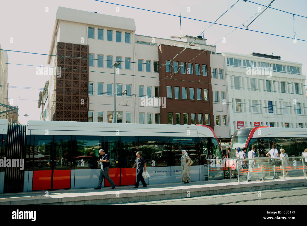 Elegante tram pausa a una centrale di Istanbul alla fermata del tram, moderni edifici per uffici in background Foto Stock
