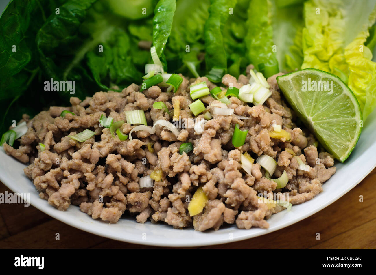 Larb - un piatto tailandese di carne macinata di maiale fritto con aglio, zenzero fresco grattugiato, peperoncino, e vestito con il succo di lime e nam pla Foto Stock