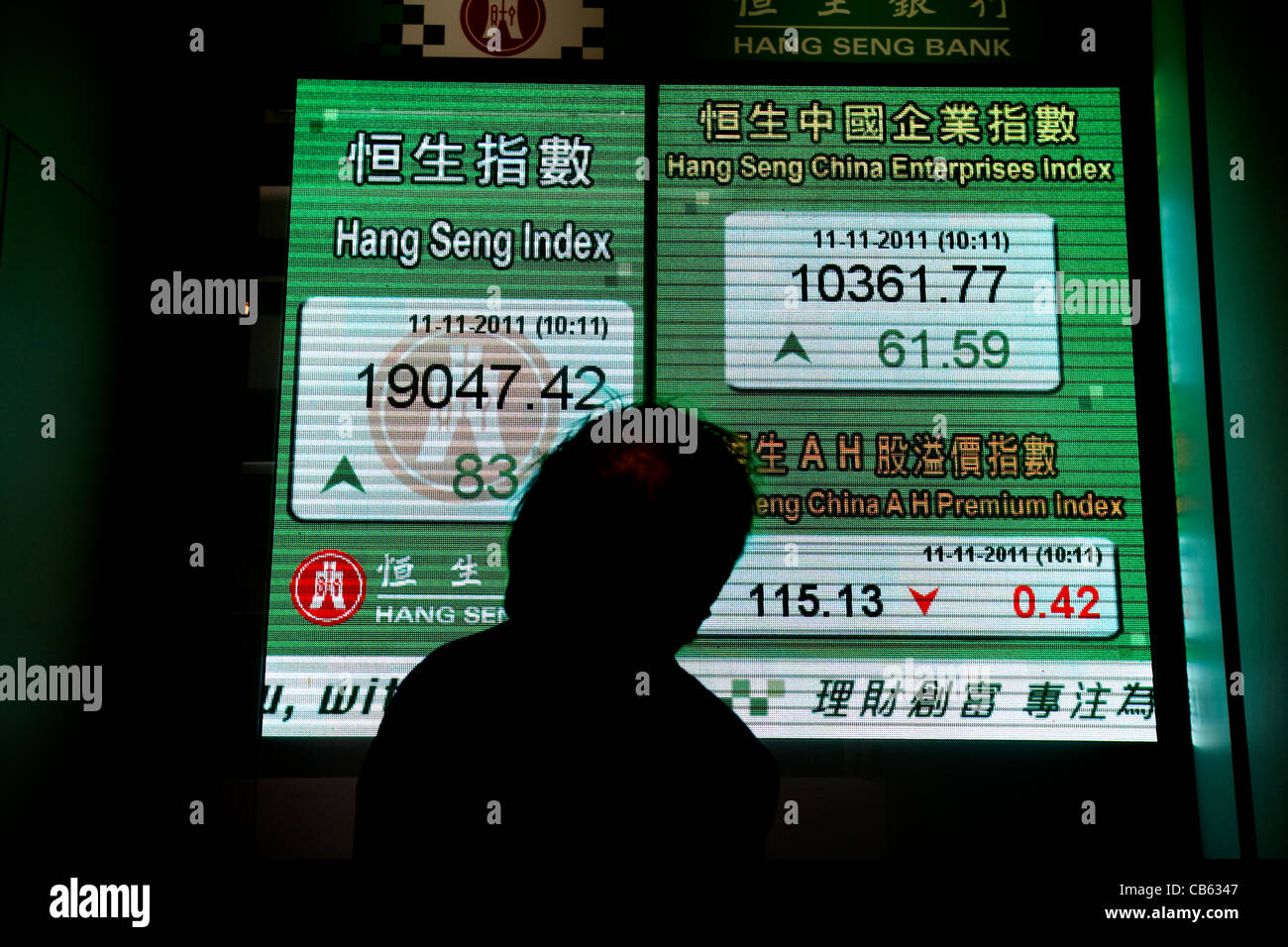 Imprenditore cinese guardando a hong kong indice azionario schermo al Hang Seng bank hq central district, isola di Hong kong, RAS di Hong Kong, Foto Stock