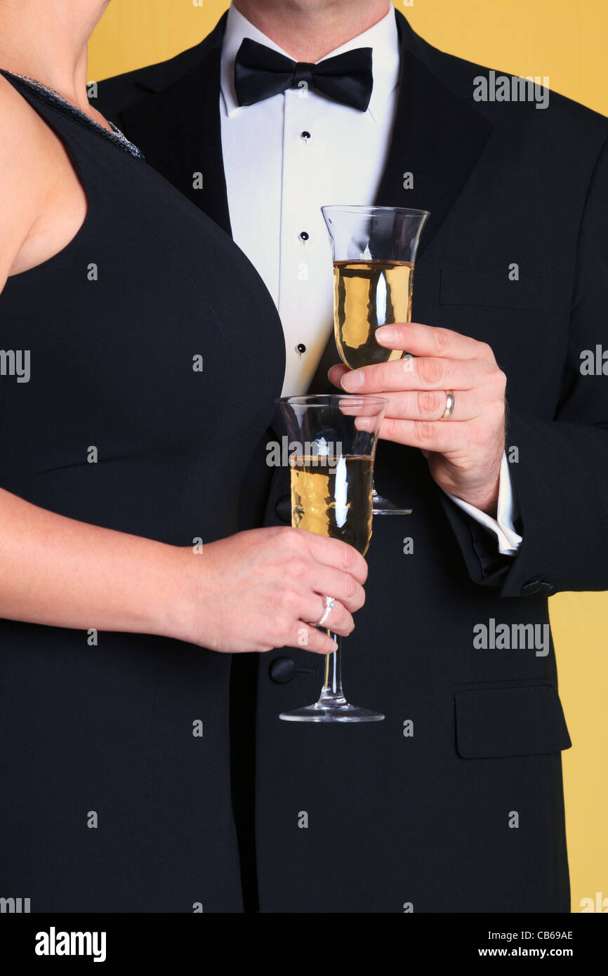 Foto di una coppia in black tie abito da sera con in mano un bicchiere di champagne. Foto Stock