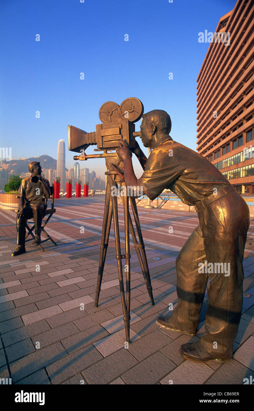 Cina, Hong Kong Kowloon, Tsim Sha Tsui, Avenue of Stars, i produttori statua con skyline della città in background Foto Stock