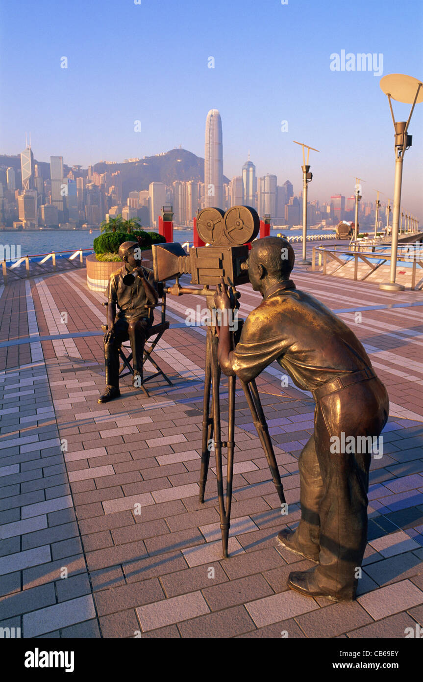 Cina, Hong Kong Kowloon, Tsim Sha Tsui, Avenue of Stars, i produttori statua con skyline della città in background Foto Stock