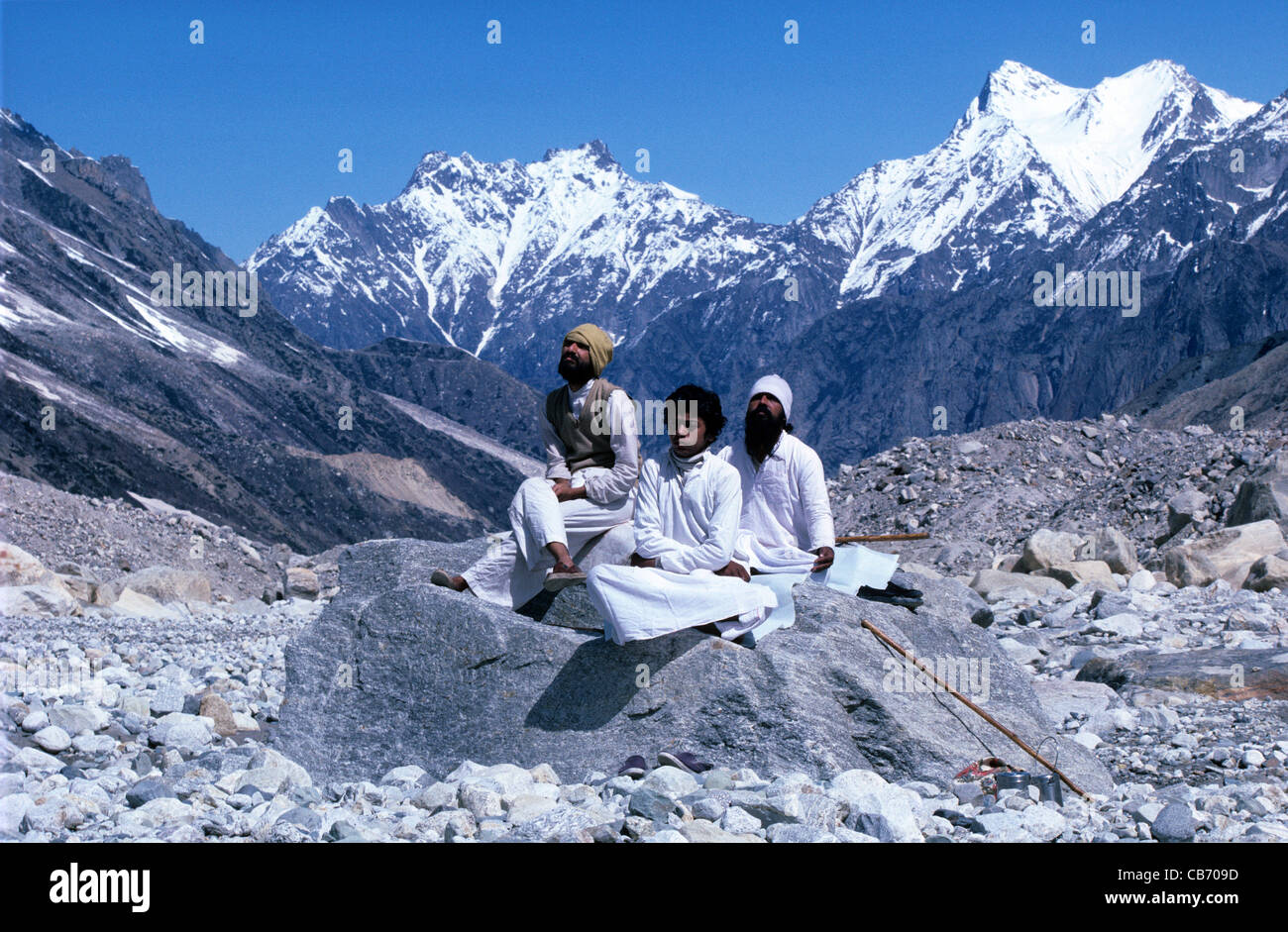 Tre uomini o pellegrini indiani che meditano alla sorgente del Gange del fiume Sacro o Sacro, Gongotri, Gaumukh, Himalaya o Monti Himalaya, India Foto Stock