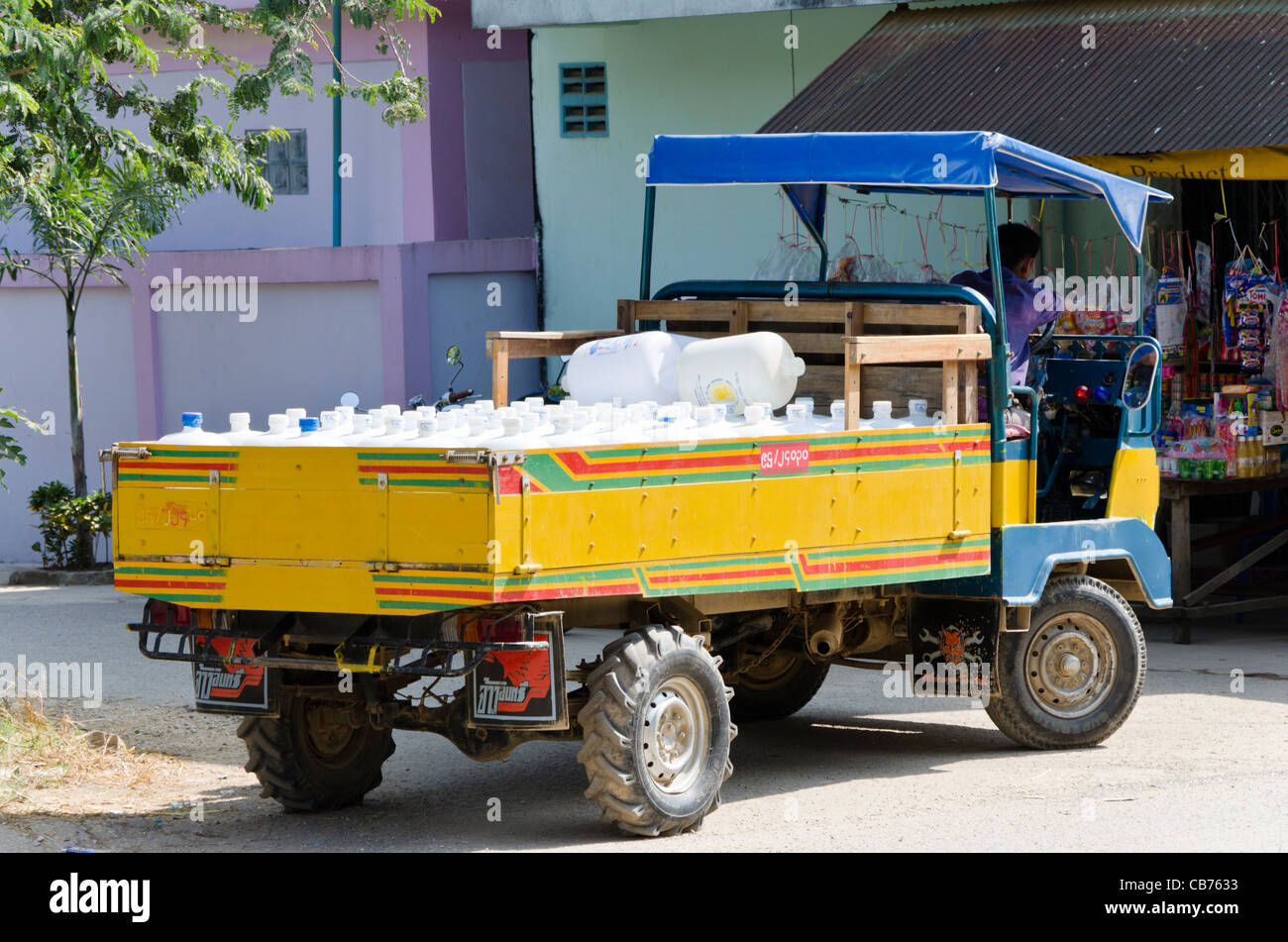 Parcheggiato giallo e blu piccolo consegna cinese carrello caricato con acqua in plastica bottiglie in Myanmar Tachileik vicino a Mae Sai in Thailandia Foto Stock