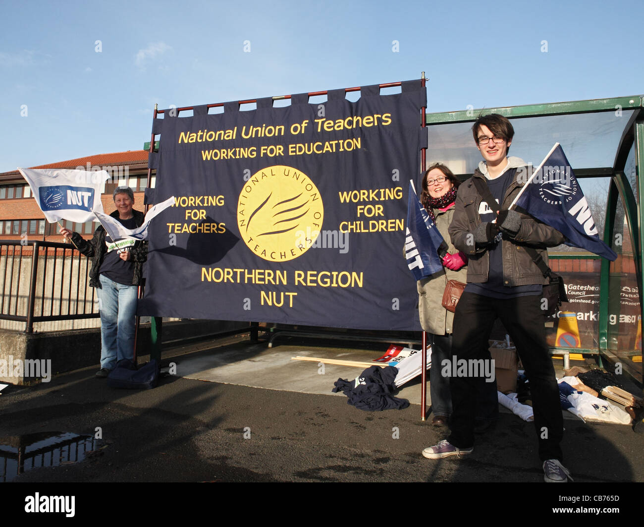 Tre insegnanti tenendo un dado banner e sventolando bandiere TUC giorno di azione Gateshead, North East England, Regno Unito Foto Stock