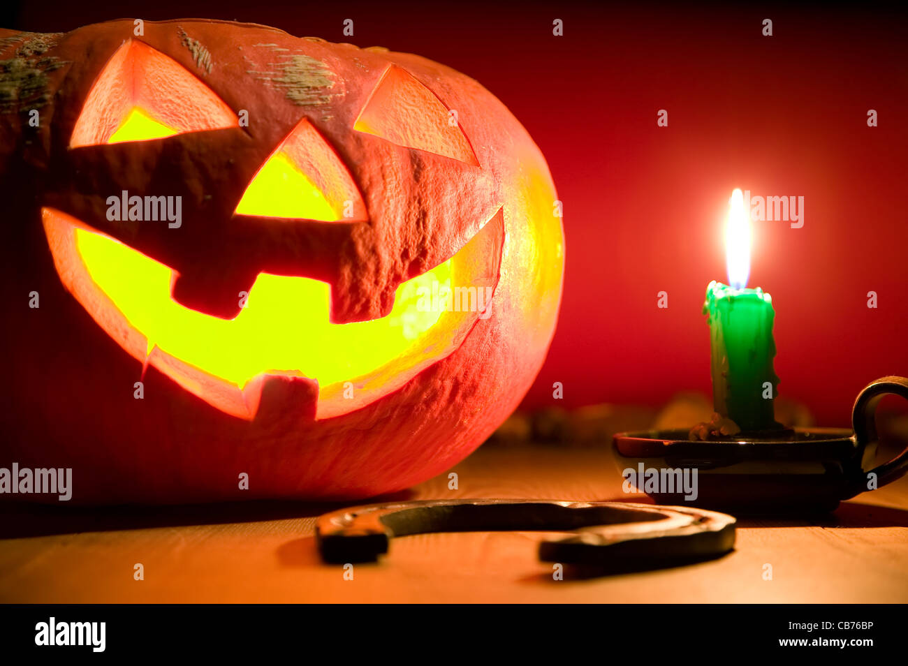 Creepy zucca vicino a candela, concetto di halloween, sullo sfondo del libro Foto Stock