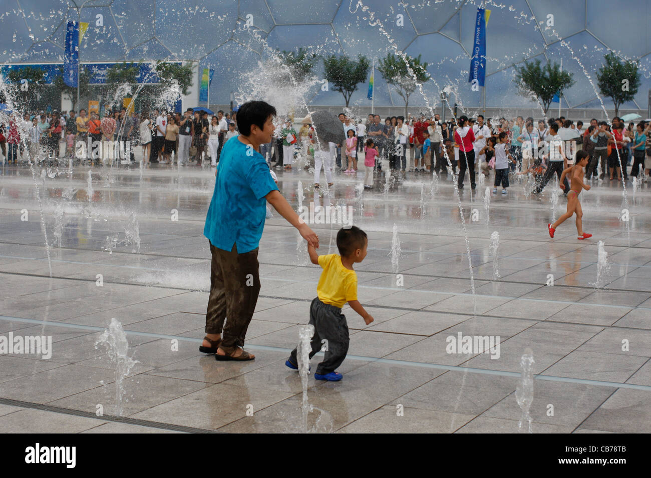 Pechino, Cina: Cinese coppie, famiglie e bambini e godetevi le vaste piazze al di fuori lo stadio nazionale durante le Paraolimpiadi invernali 2008 Foto Stock