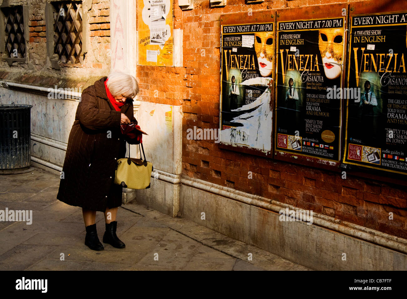 Donna veneziano cercando nella sua borsa per denaro Foto Stock