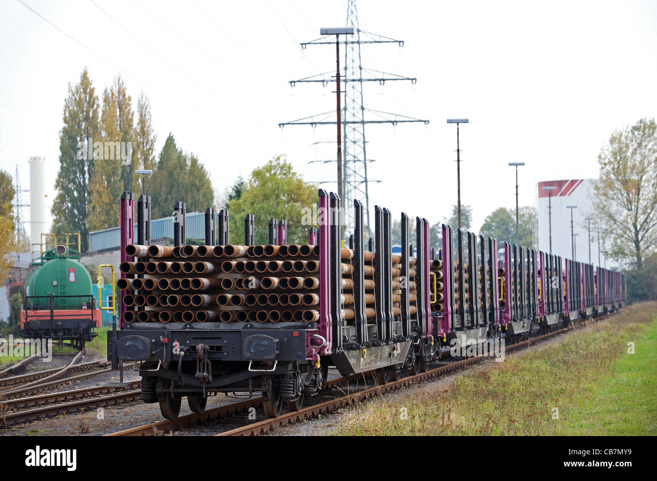 Le ferrovie tedesche flatbed di carri carichi con tubi di acciaio, Dusseldorf, Germania. Foto Stock