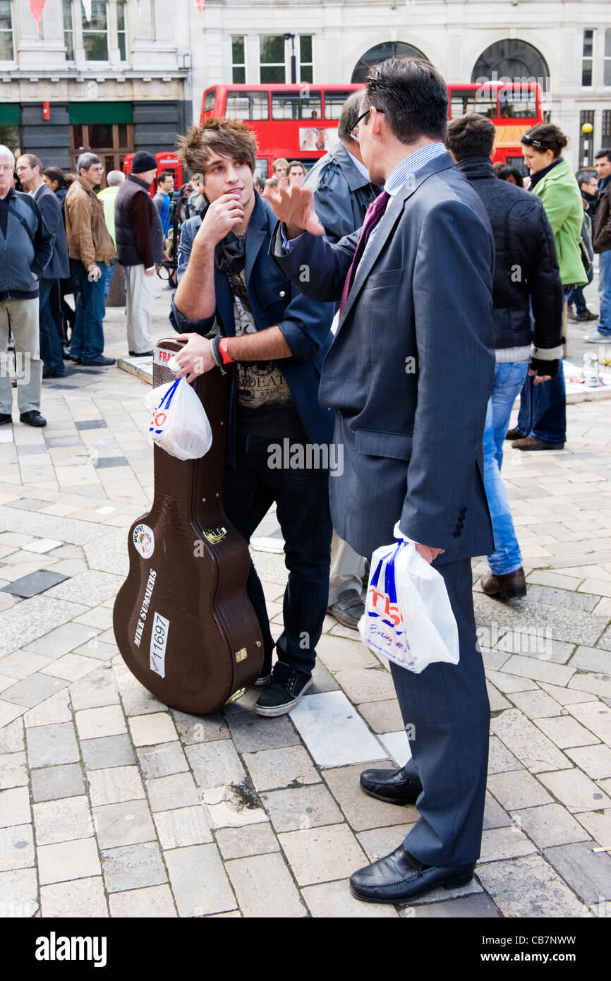 La Cattedrale di St Paul e la Tendopoli occupare Londra anti capitalista manifestanti manifestanti attivisti ragazzo parla di chitarra chat smart adatto lavoratore bus rosso Foto Stock