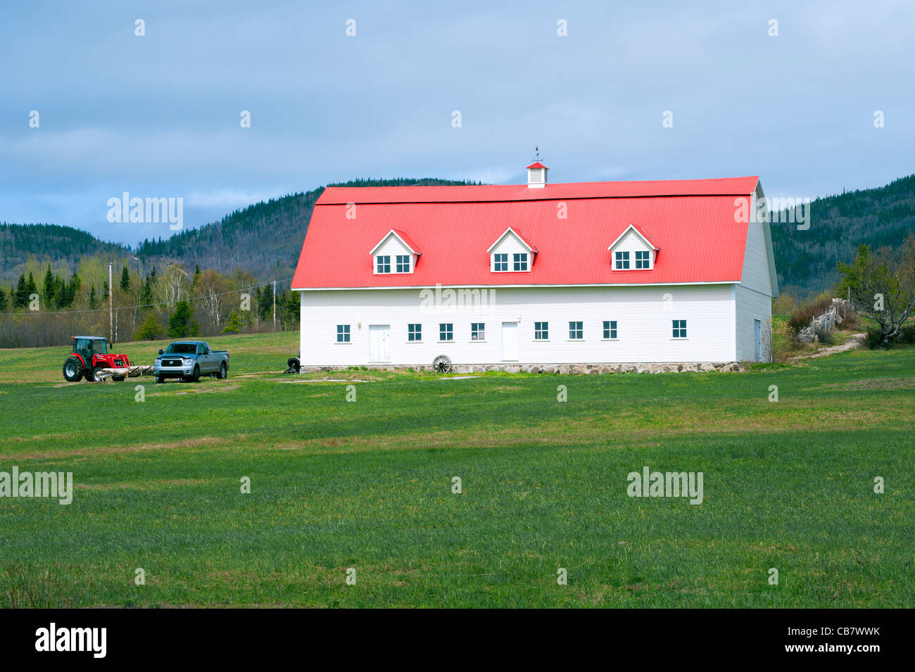 White Barn con tetto arancione nella regione di Charlevoix, provincia del Québec in Canada. Foto Stock