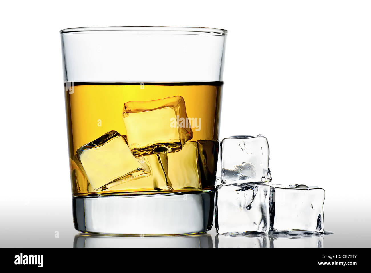 Un bicchiere di whisky sulle rocce con cubetti di ghiaccio accanto a, isolato su bianco Foto Stock