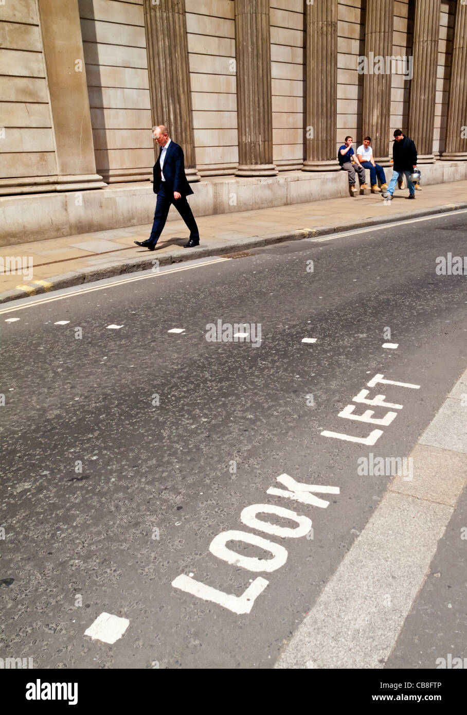 I pedoni a piedi nella parte anteriore della Bank of England edificio Threadneedle Street City di Londra con guardare a sinistra dipinto in strada Foto Stock