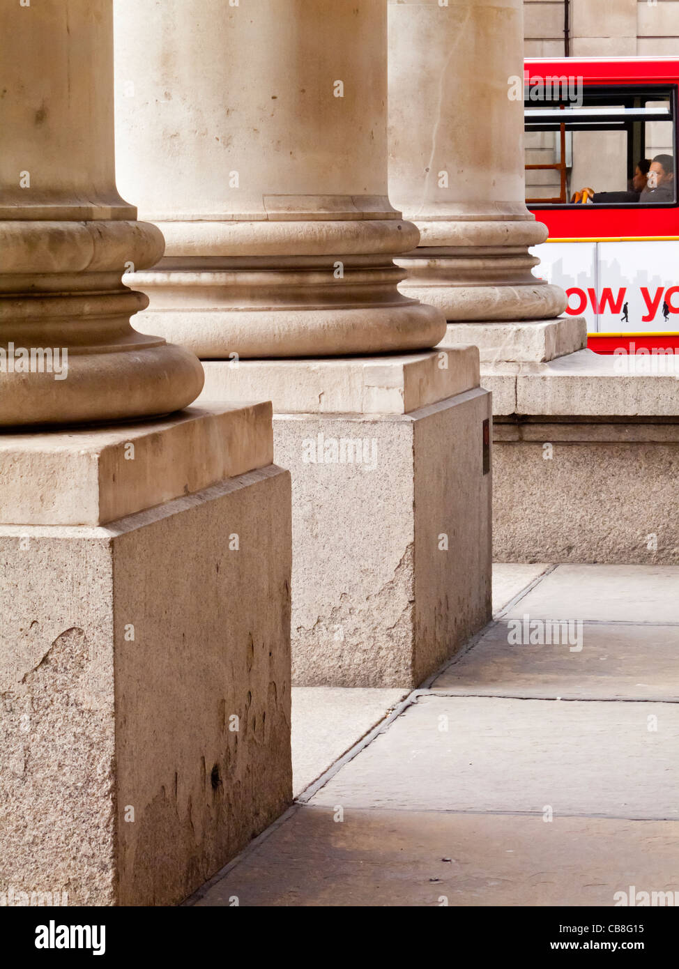 Dettaglio delle colonne in pietra all'ingresso del Royal Exchange edificio nella città di Londra Inghilterra con il bus rosso a distanza Foto Stock