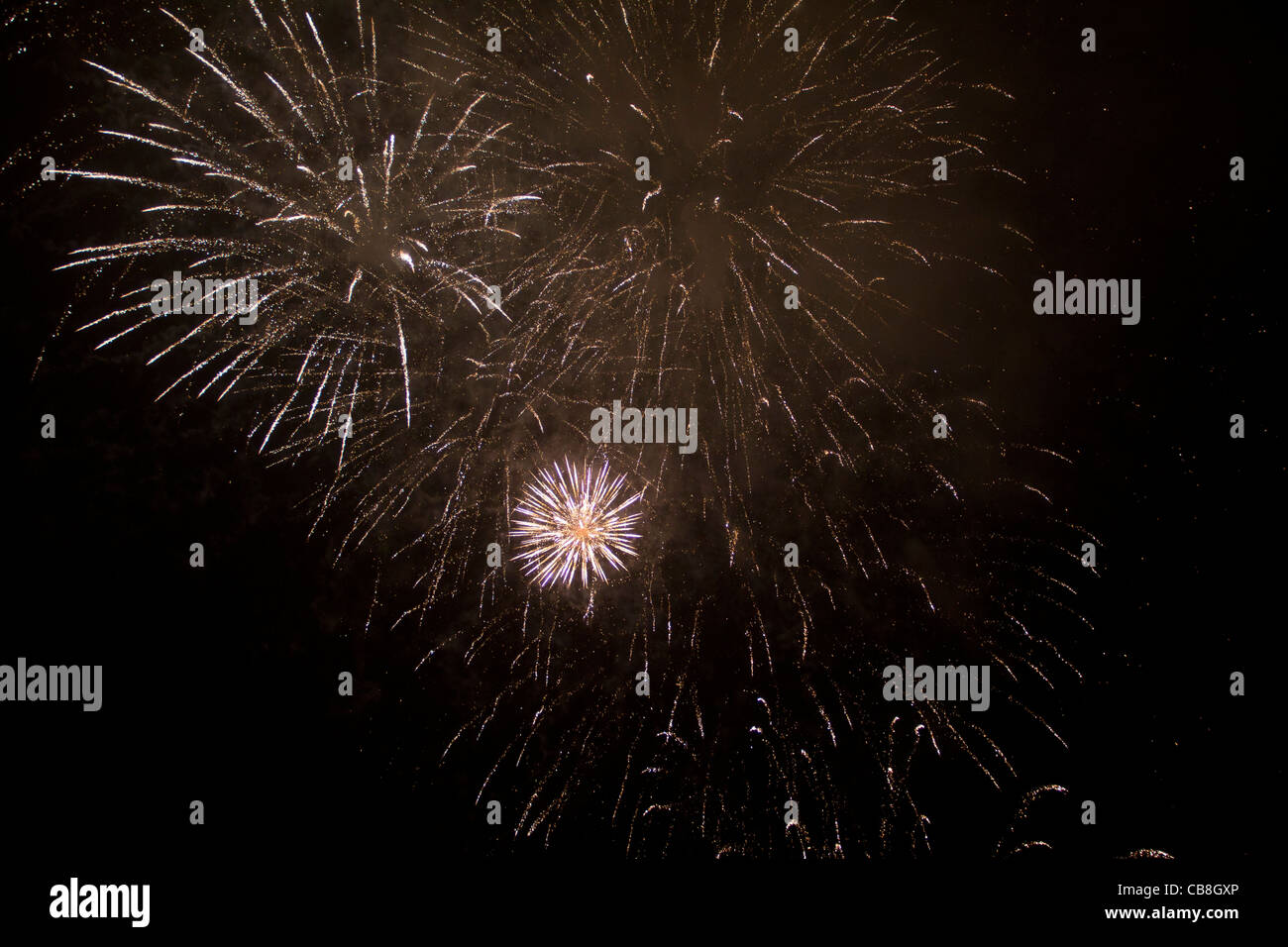 Giallo enorme esplosione di fuochi d'artificio con piccole esplosioni in background. Alcuni sono grandi e altri più piccoli e molto luminoso. Foto Stock