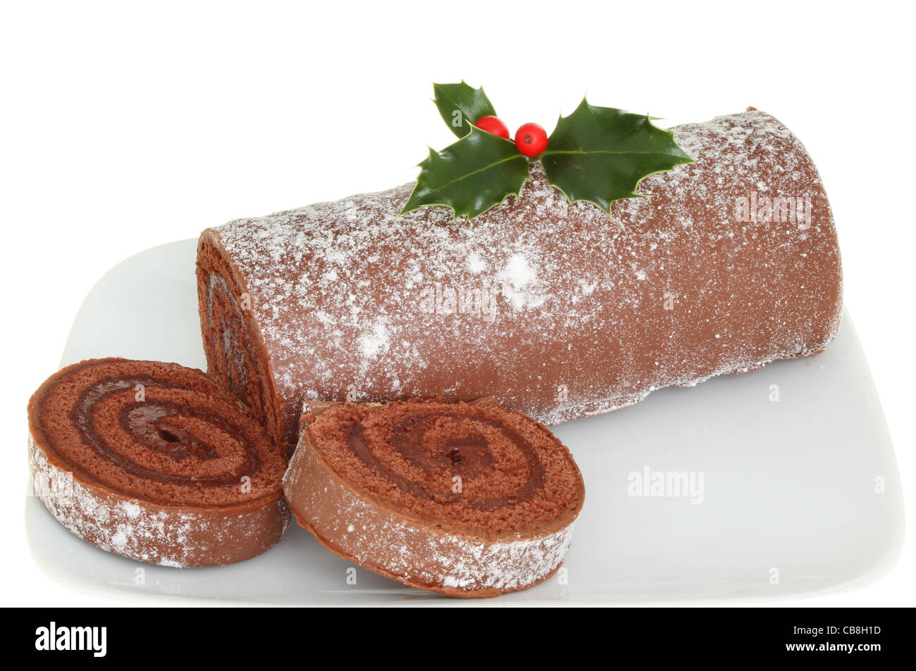 Primo piano di un Natale a fette registro di cioccolato decorate con agrifoglio Foto Stock