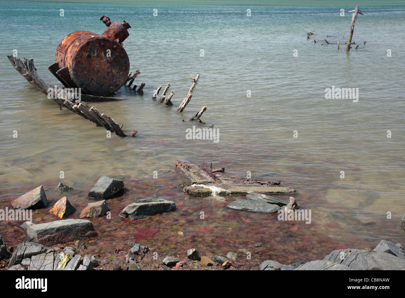 Una vecchia barca marcio con la caldaia a vapore ancora rimanente. Bluff, Nuova Zelanda. Foto Stock