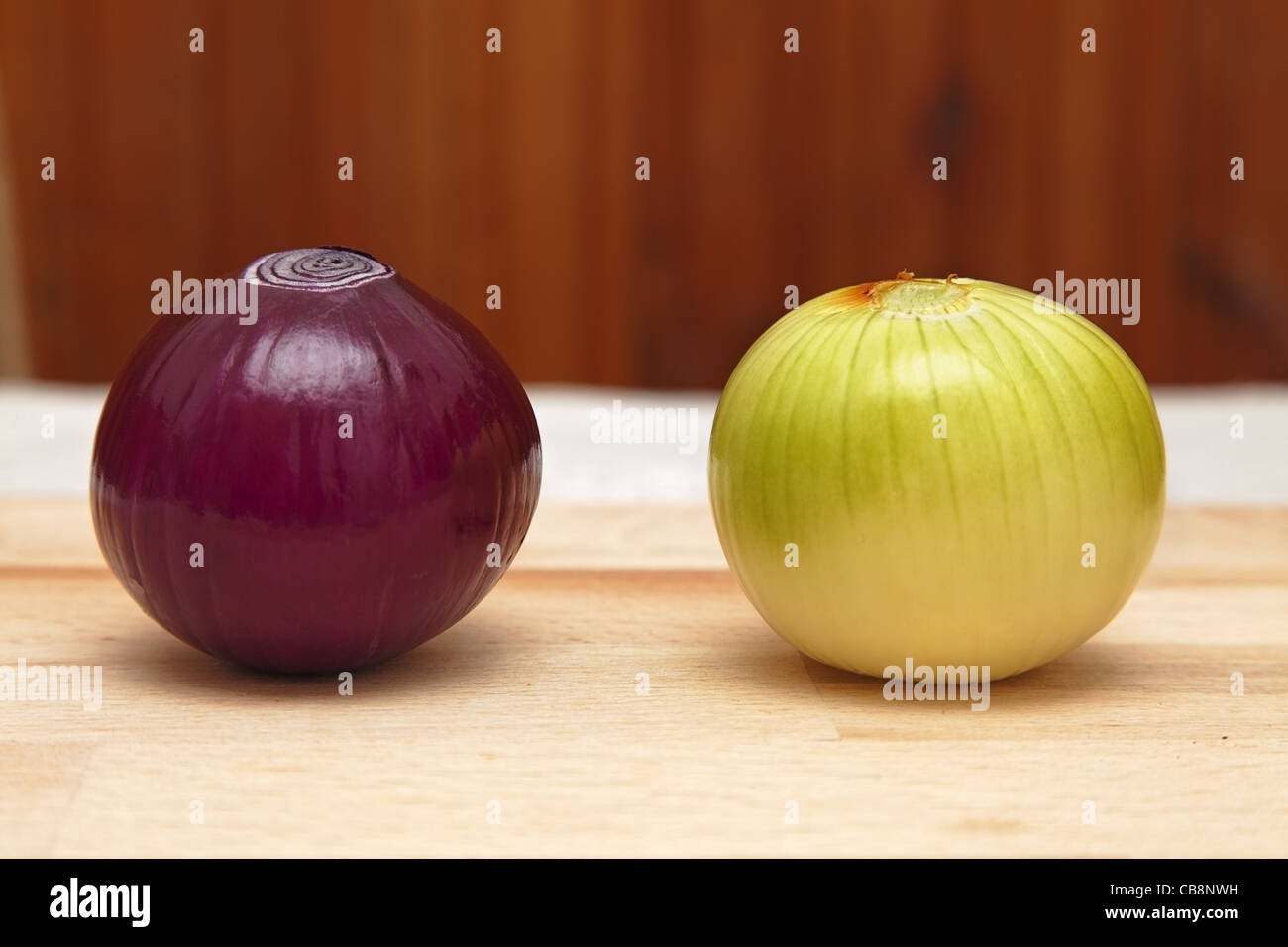 Immagine di due differenti cipolle su un tavolo da cucina. Foto Stock