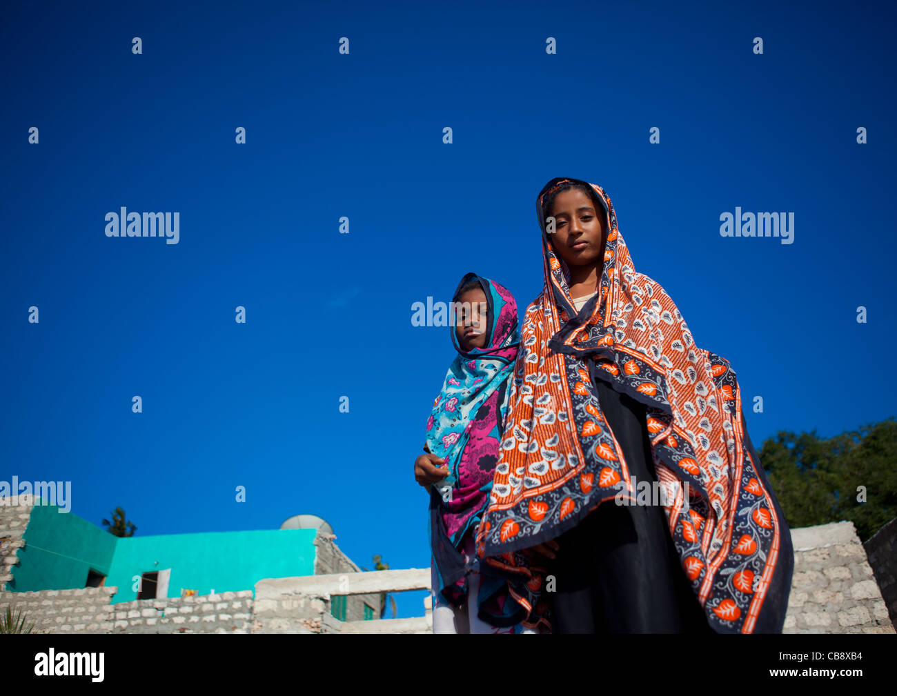 Matondoni paio di ragazze adolescenti in veli colorati per le strade, Lamu, Kenya Foto Stock