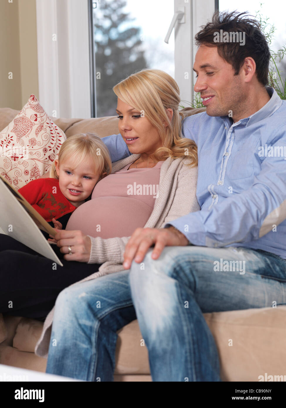 Felice marito e una figlia di una donna incinta godendo il loro tempo insieme a casa Foto Stock