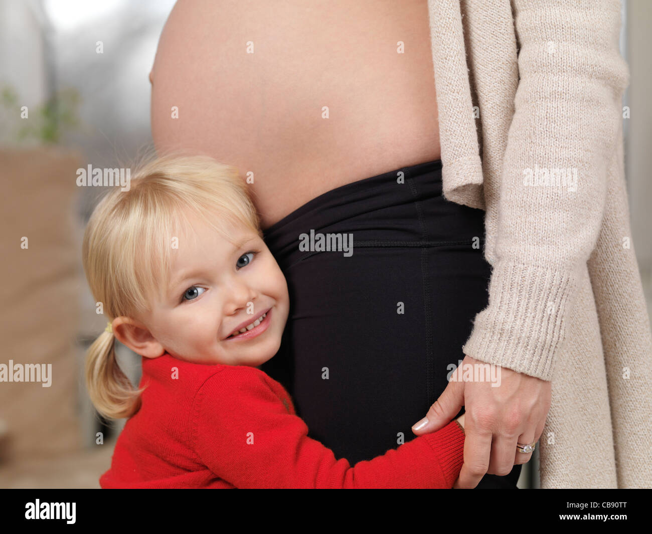 Donna incinta e il suo felice anno tre vecchi piccola figlia insieme Foto Stock