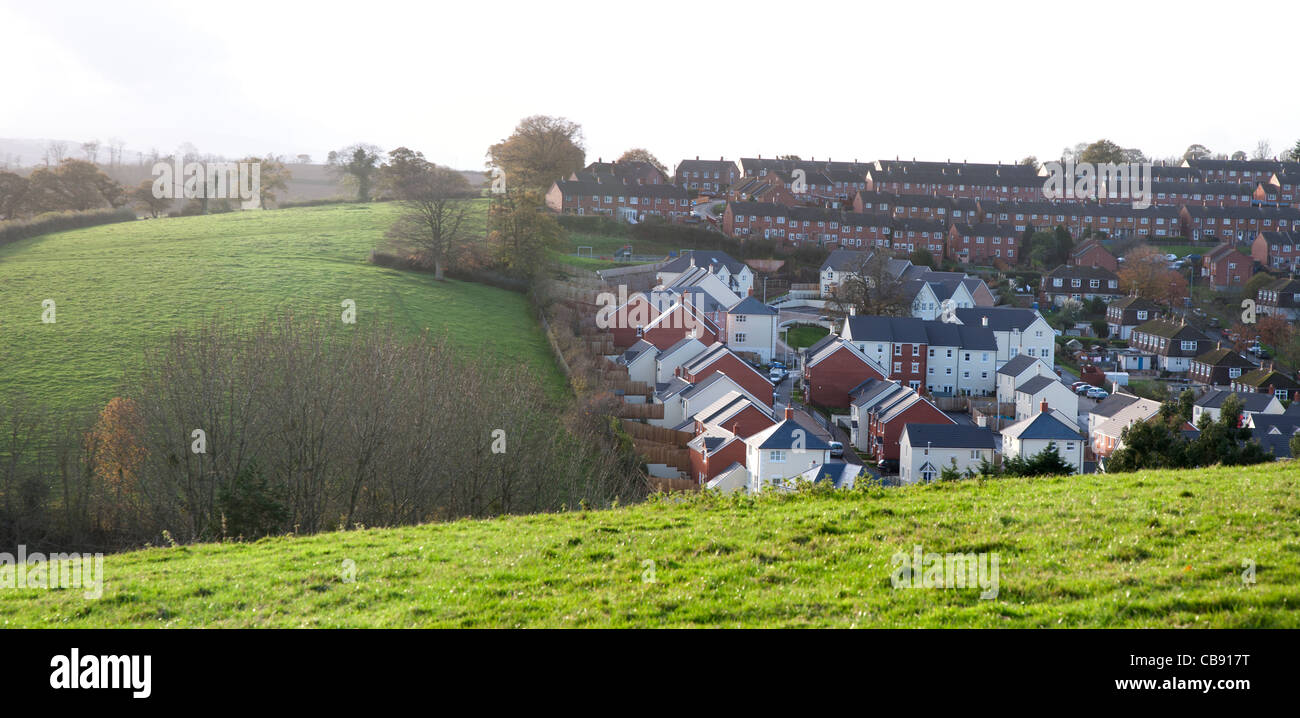 Nuove case costruite sul sito di un antico frutteto (nastro verde) accanto ai campi aperti a Crediton, Devon, Inghilterra Foto Stock