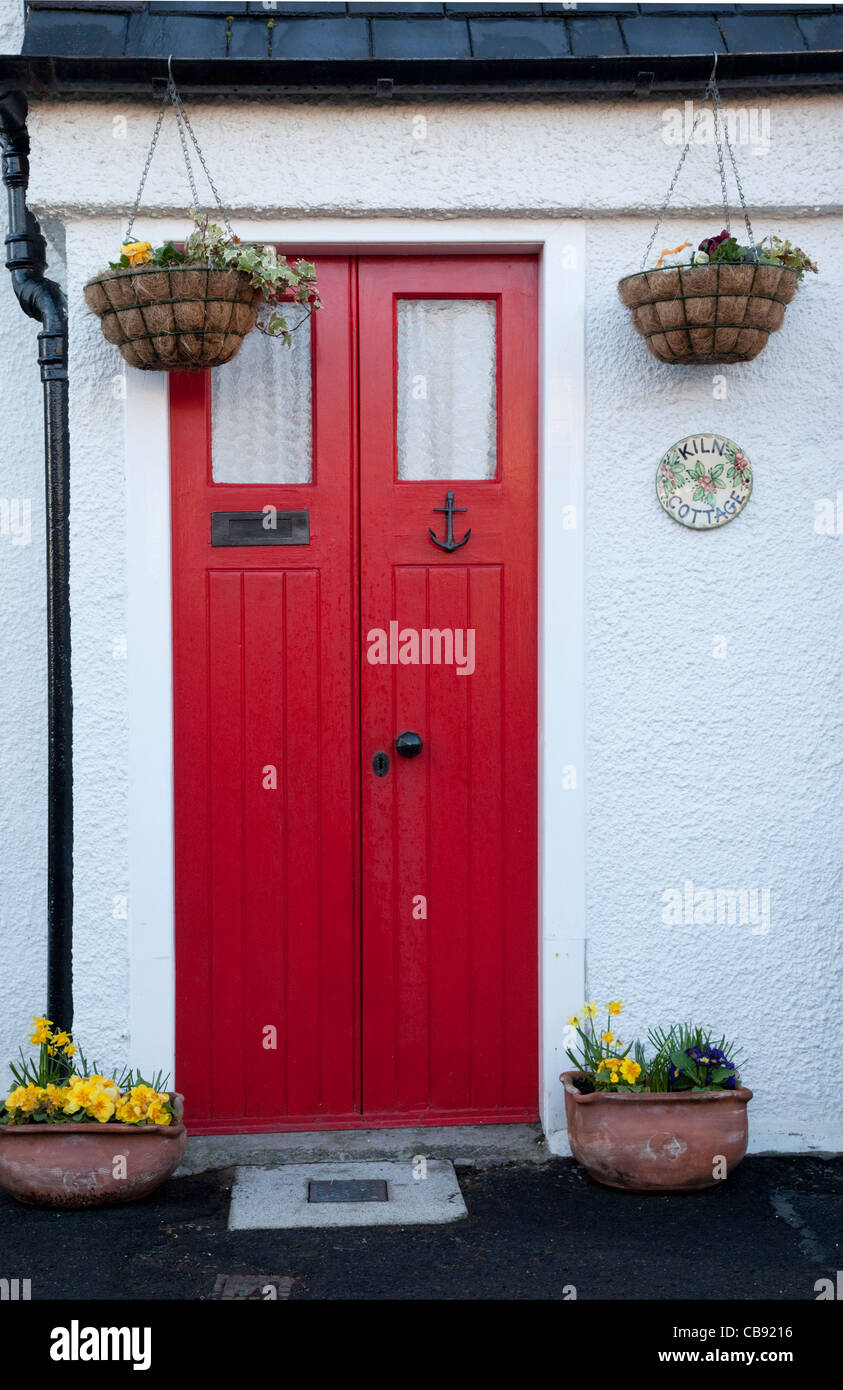 Porta Rossa e la parete dipinta di bianco di un cottage, Crail, East Neuk di Fife, Scozia Foto Stock
