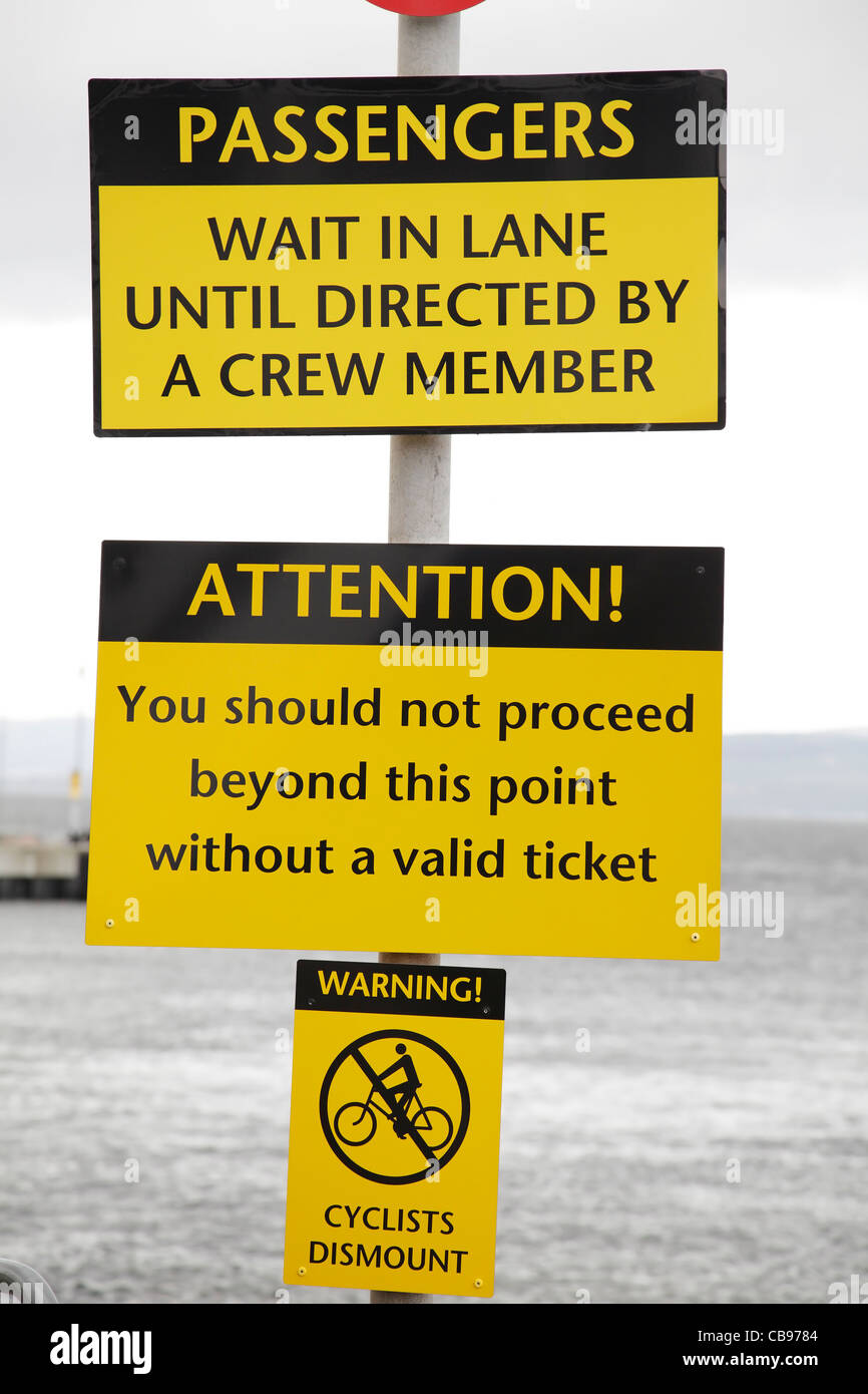 Segnali di avvertimento per i passeggeri sullo scivolo per il traghetto Calmac Largs to Great Cumbrae, Scozia, Regno Unito Foto Stock