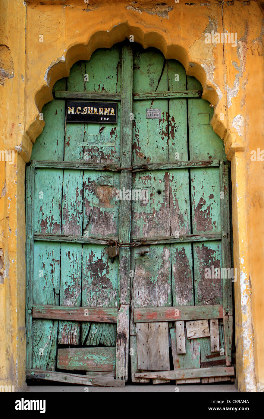 Vivido verde vecchia porta di legno e pareti di colore arancione in Bundi. Il Rajasthan. India Foto Stock