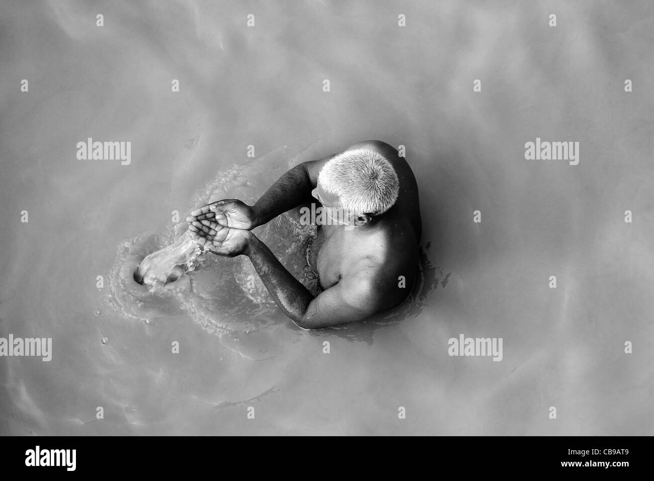 Uomo indiano pregando immerso nel sacro Gange fiume. India Foto Stock