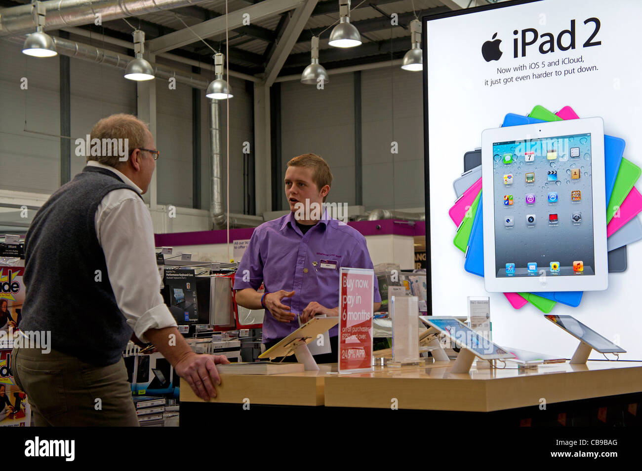 Un membro del personale di un mondo PC store dimostrando un Apple IPAD 2 a un cliente, REGNO UNITO Foto Stock