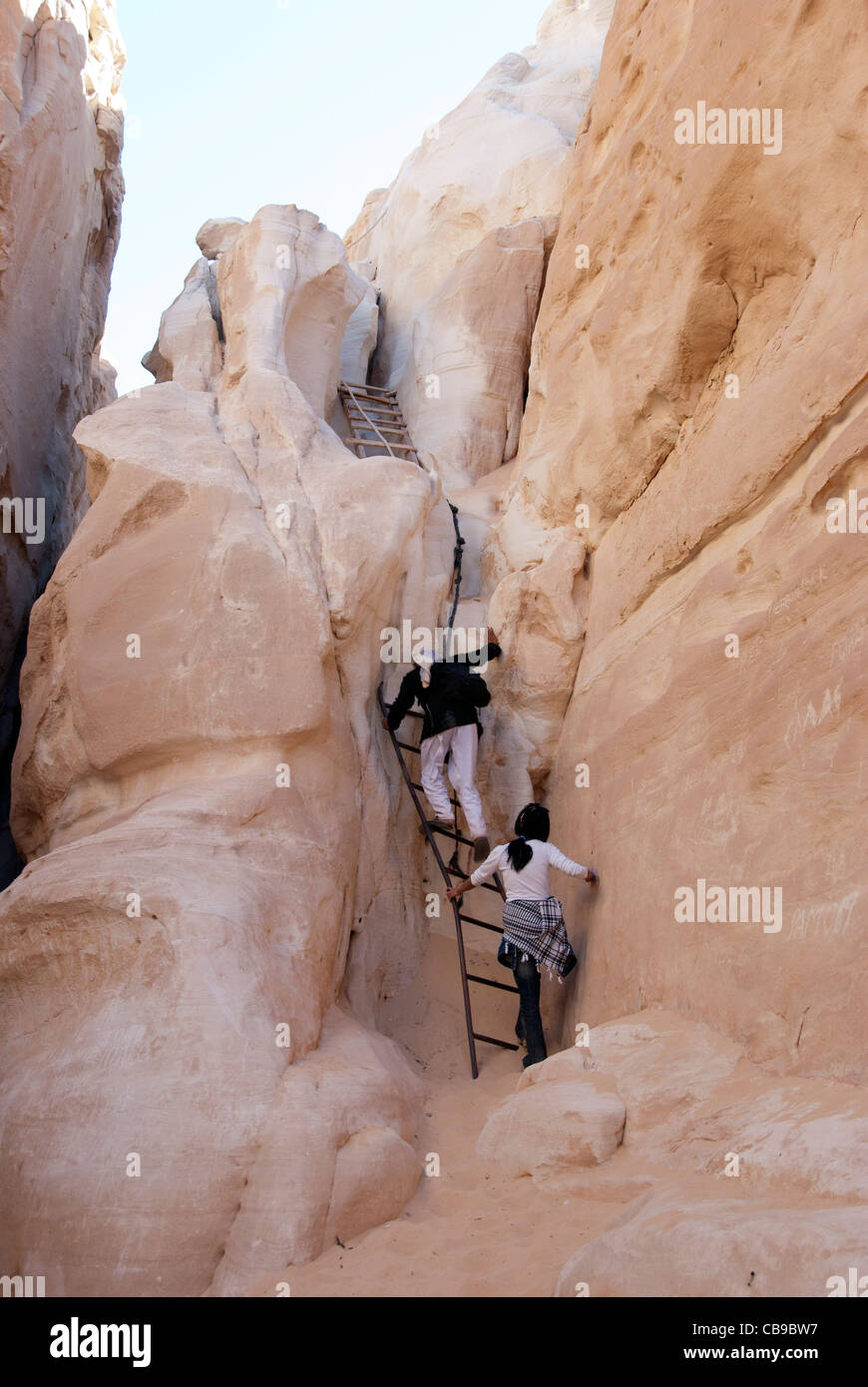 Guida Beduina con tourist salire le scale nel canyon bianco - Penisola del Sinai, Egitto Foto Stock