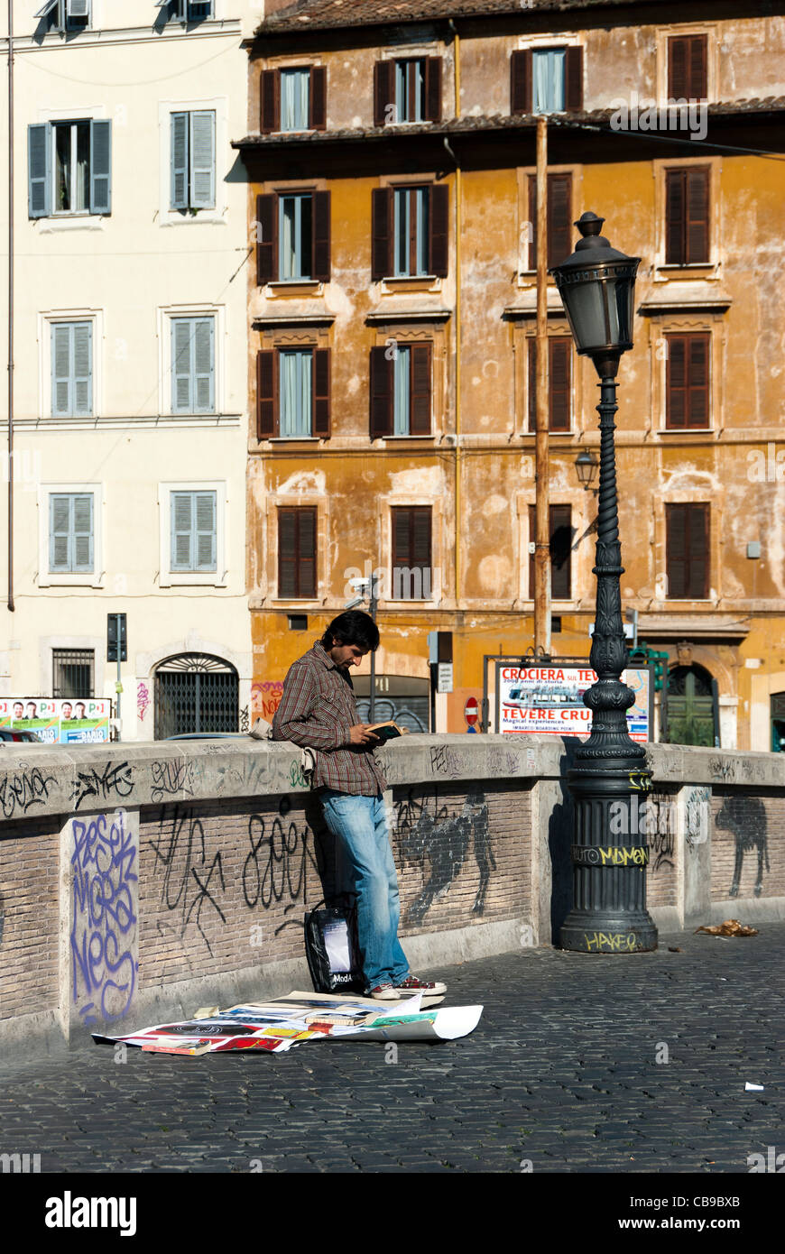 Venditore ambulante la lettura di un libro su Ponte Sisto a Roma - Italia Foto Stock