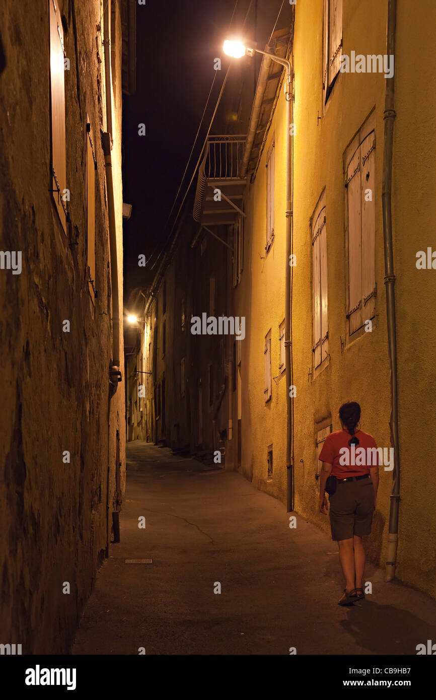 Donna che cammina da sola in uno stretto vicolo di notte Camares Francia Foto Stock