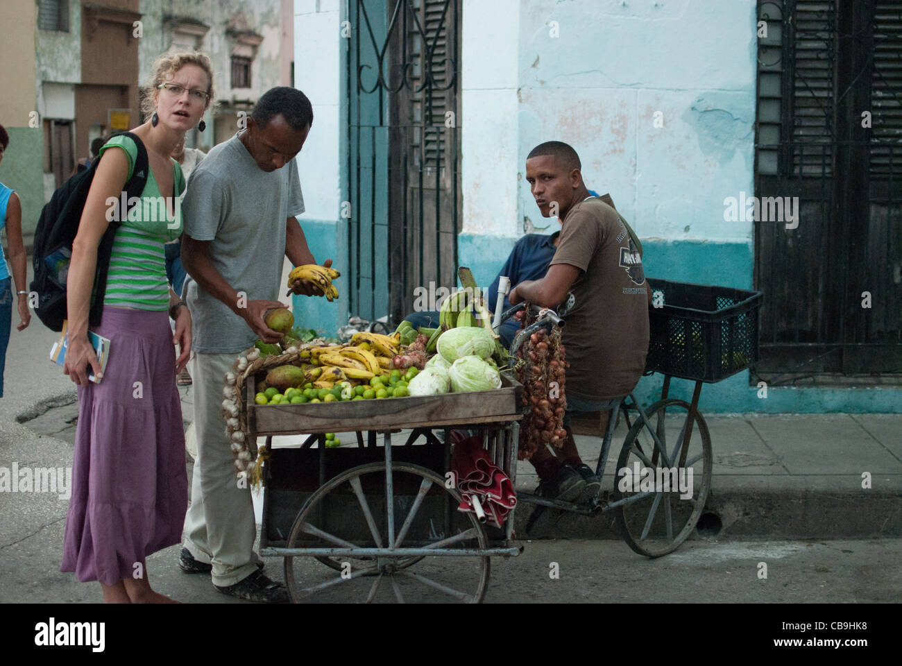 Turista femminile comprare la frutta sulla frutta stand per il popolo cubano, Santa Clara, Cuba Foto Stock
