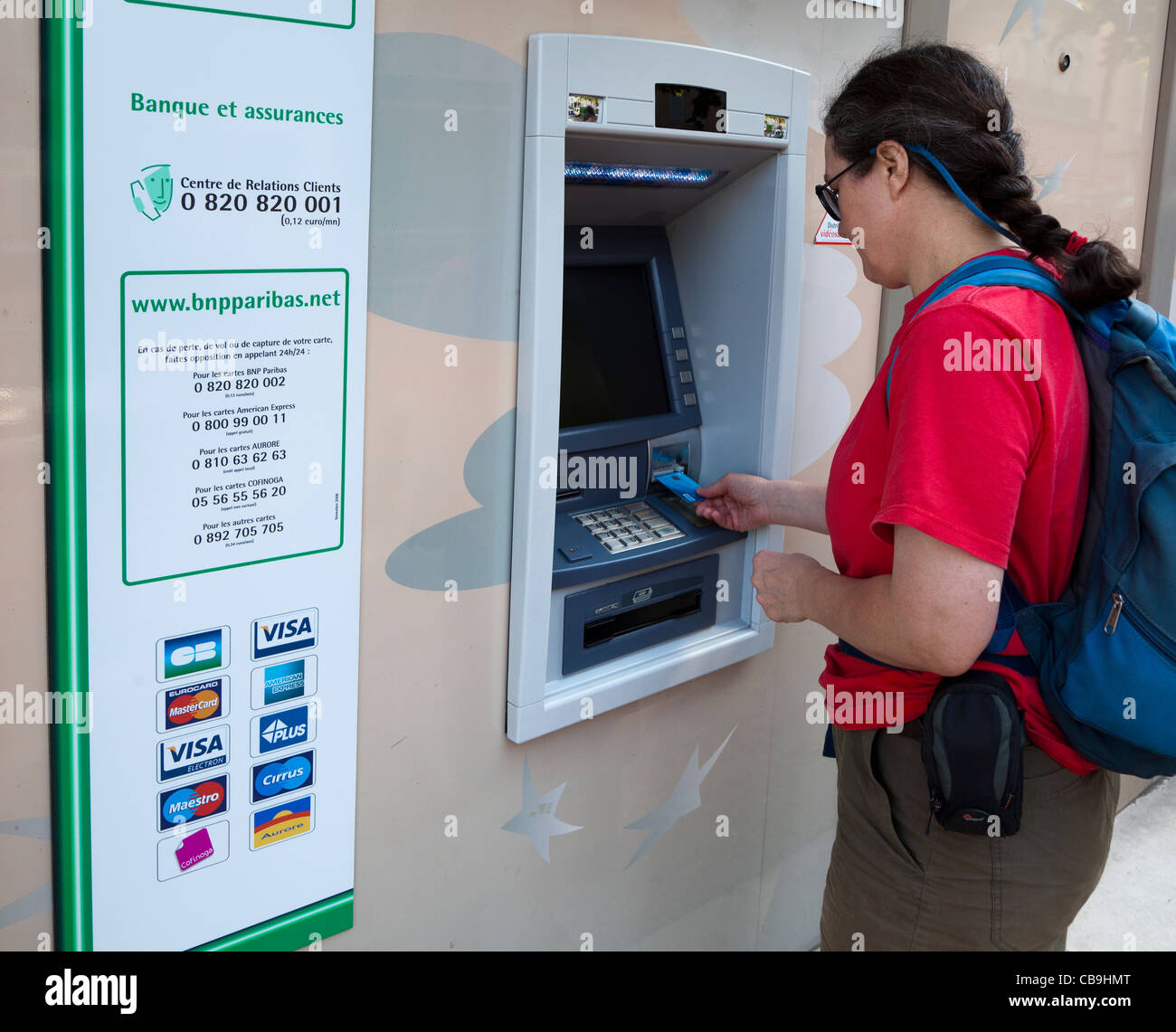Donna che utilizza carta per ottenere denaro da banca francese macchina St Affrique Francia Foto Stock
